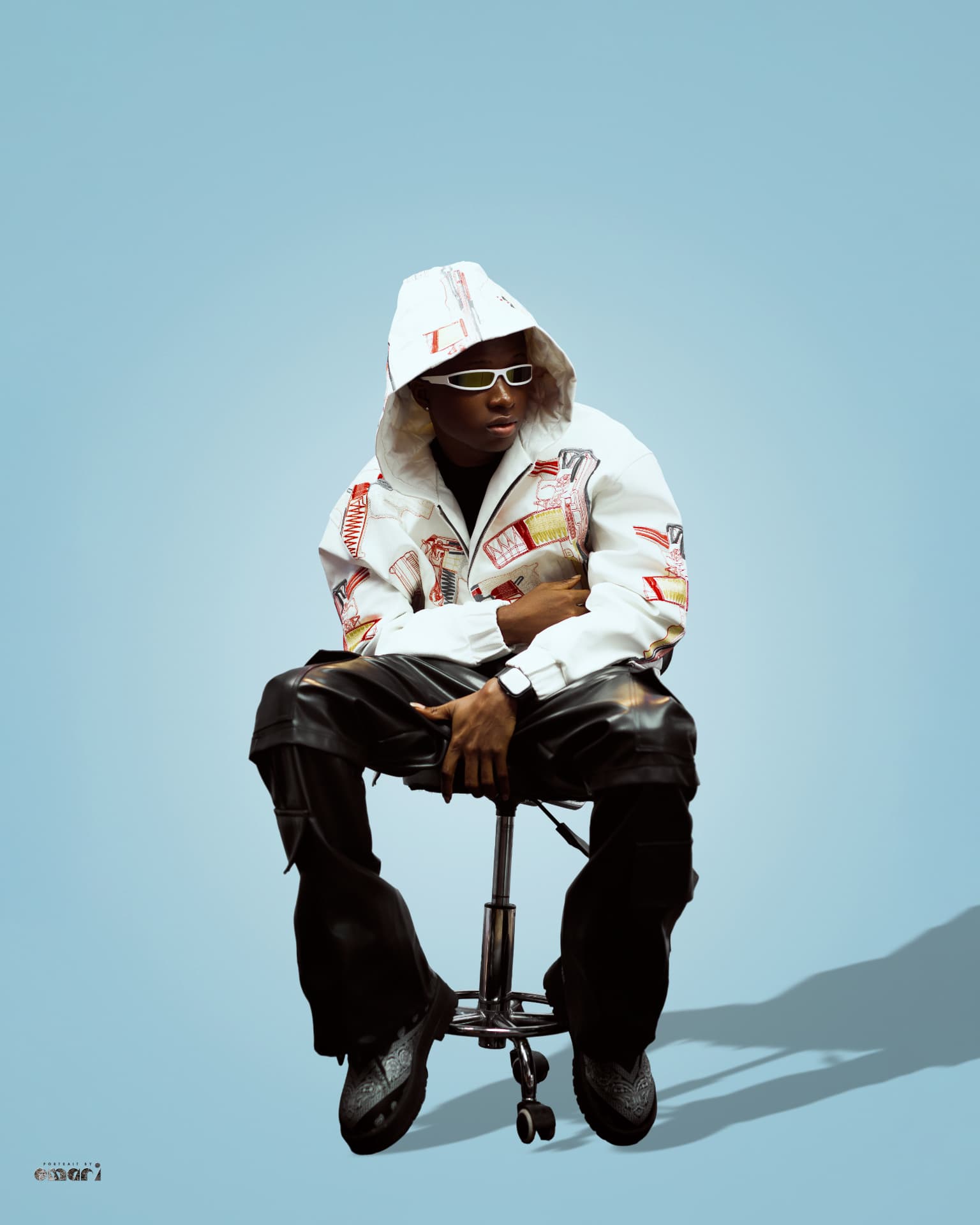 Boyyana seated leaning forward on a studio stool
