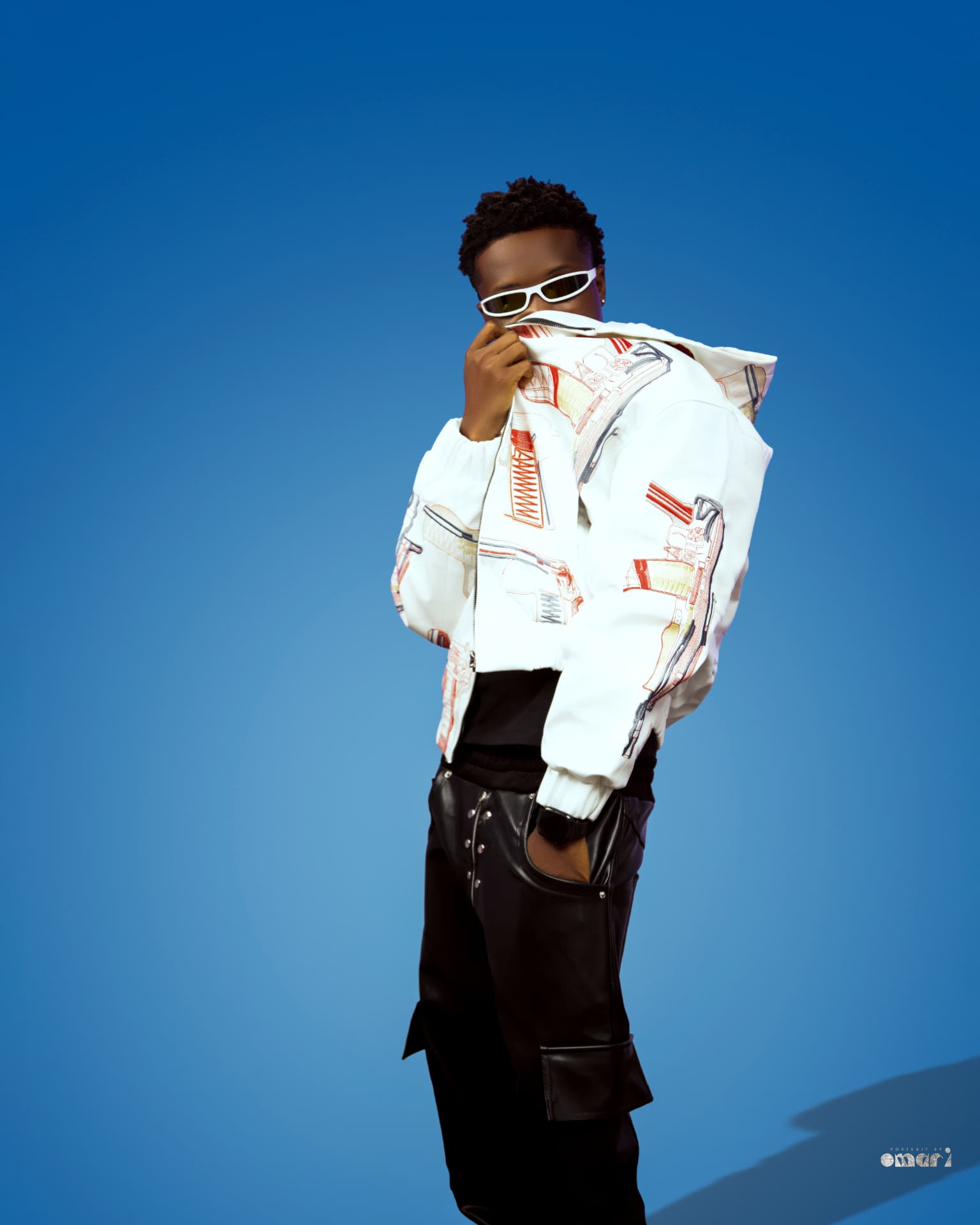 Boyyana zipping up a white embroidered jacket