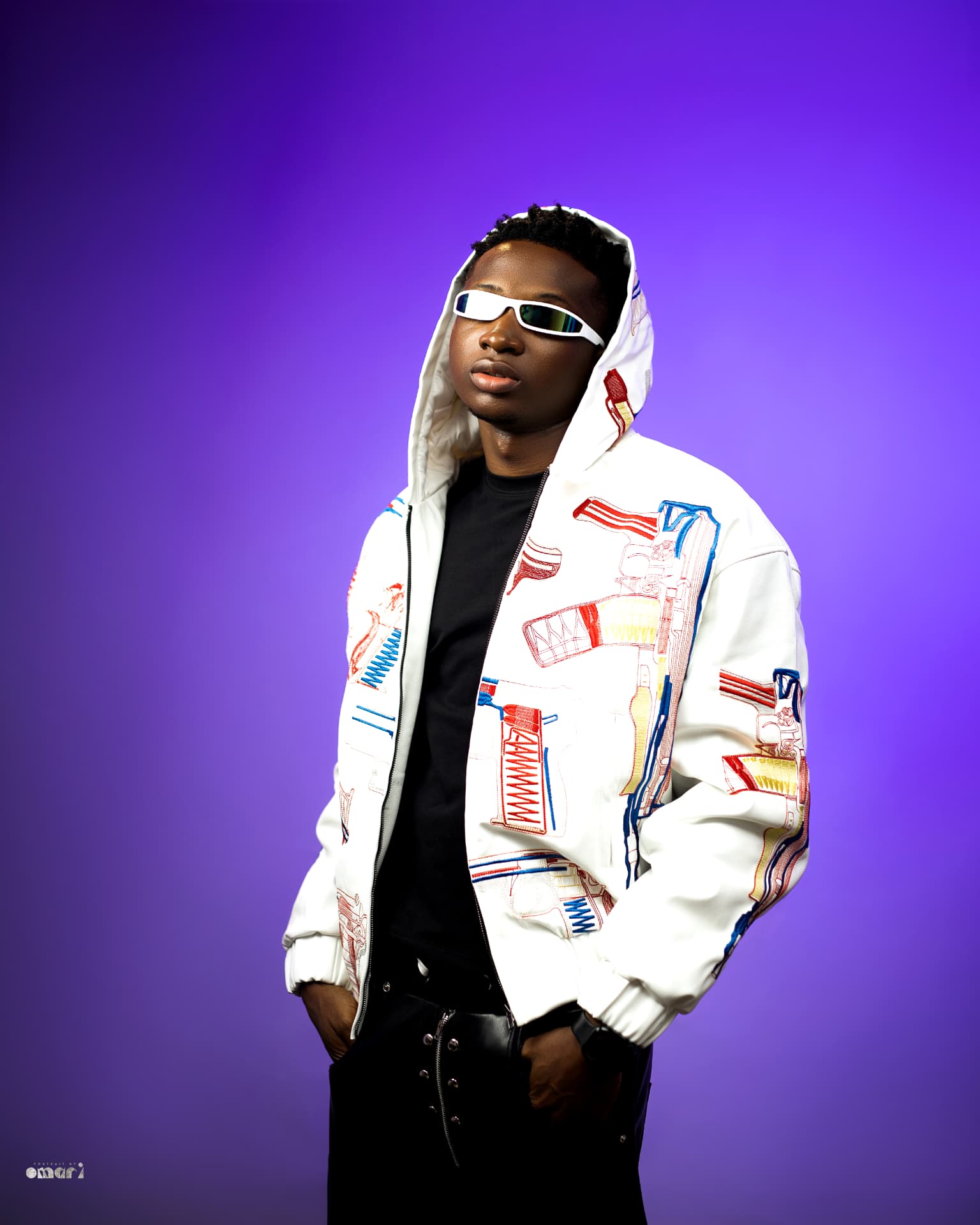 Boyyana in a white embroidered jacket and white sunglasses on a purple backdrop