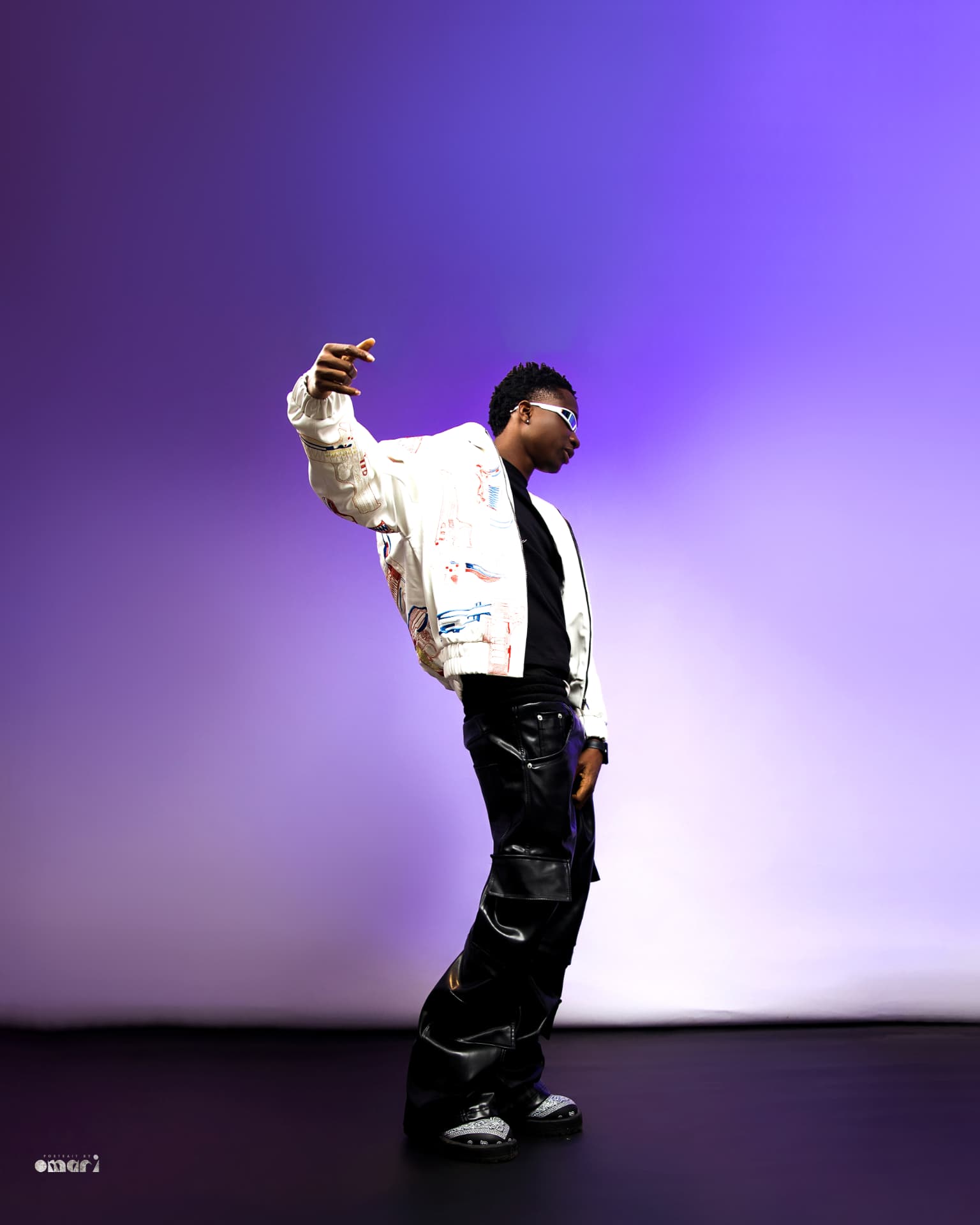 Boyyana mid-motion with arm outstretched on a purple stage